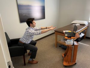 Male therapist in telehealth physical therapy session